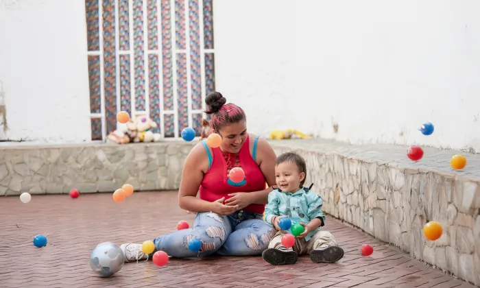 madre-jugando-con-hijo-pelotas-colores